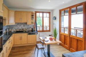 uma cozinha com armários de madeira e uma mesa de madeira em La Villa des Grillons, outstanding lake view and private garden - LLA Selections by Location Lac Annecy em Veyrier-du-Lac