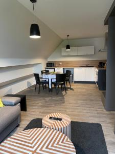 een woonkamer met een tafel en stoelen en een keuken bij Appartements de Manon au cœur des vignes in Kientzheim