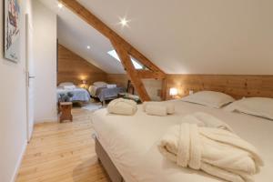 a bedroom with a large bed with white sheets at La Villa des Grillons, outstanding lake view and private garden - LLA Selections by Location Lac Annecy in Veyrier-du-Lac
