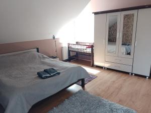 a bedroom with a bed and a dresser with a mirror at Dom na Konwaliowej in Narew