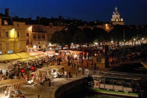 una multitud de personas caminando por el mercado por la noche en Hôtel de l'Océan, en La Rochelle