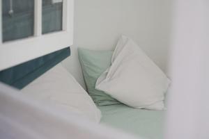 almohada blanca sentada en una cama junto a una ventana en Marseille A la bien Vieux port - Paradis, en Marsella
