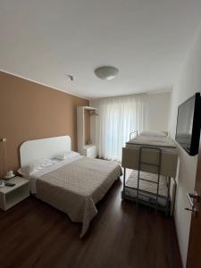 1 dormitorio con 1 cama y TV de pantalla plana en Hotel Playa, en Bibione