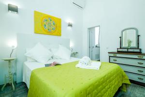 - une chambre avec un lit jaune, une commode et un miroir dans l'établissement Casa Ella, à Olhão