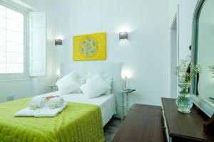une chambre d'hôtel avec un lit et une table avec des serviettes dans l'établissement Casa Ella, à Olhão