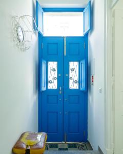 une porte bleue dans une pièce avec un banc dans l'établissement Casa Ella, à Olhão