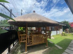 eine Hütte mit Stühlen und einem Strohschirm in der Unterkunft Dolce Vita Resort in Moalboal