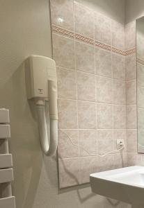 a bathroom with a toilet and a phone on the wall at Bel appartement, bien équipé et confortable dans le centre historique in Fougères