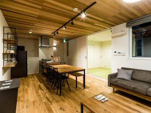 eine Küche und ein Wohnzimmer mit einem Tisch und einem Sofa in der Unterkunft Rakuten STAY HOUSE x WILL STYLE Hagi Nishitamachi in Hagi