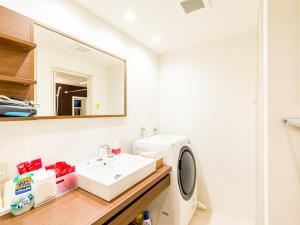 ein Badezimmer mit einem Waschbecken und einer Waschmaschine in der Unterkunft Rakuten STAY HOUSE x WILL STYLE Hagi Nishitamachi in Hagi