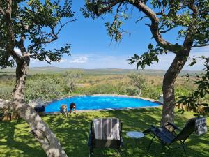 a group of people standing around a pool in a yard at Mountain Peak Game Lodge and Camping in Ozongaka