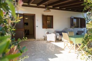un patio con tavolo, sedie e divano di Azienda Agrituristica Scalelle a Otranto
