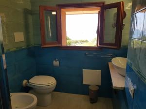 bagno con servizi igienici, lavandino e finestra di Accu is prezzus I 30mt dal mare a Villasimius