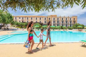a family walking by the pool at the resort at Villa Zina Family Resort in Custonaci