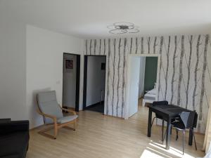 Ferienwohnung Auszeit في روستوك: غرفة معيشة مع طاولة وكرسي