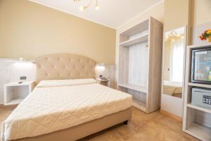 1 dormitorio con cama, ventana y TV en Hotel Salento Mirfran, en Torre San Giovanni