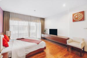 sypialnia z łóżkiem, telewizorem i krzesłem w obiekcie Chateau Dale Boutique Resort Spa Villas w Pattaya South
