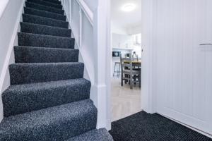 a staircase in a house with blue carpet at Beautiful 3 bedroom property , Sleeps 6 in Crewe