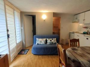 ein Wohnzimmer mit einer blauen Couch in einer Küche in der Unterkunft Appartement Cauterets, 2 pièces, 6 personnes - FR-1-234-127 in Cauterets