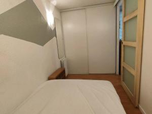 ein Schlafzimmer mit einem Bett und einer Schiebetür in der Unterkunft Appartement Cauterets, 2 pièces, 6 personnes - FR-1-234-127 in Cauterets