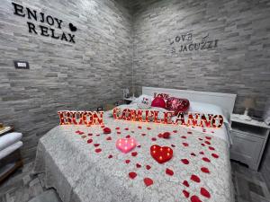 Un dormitorio con una cama con corazones rojos. en Il FAUNO - Suite & SPA en Scafati