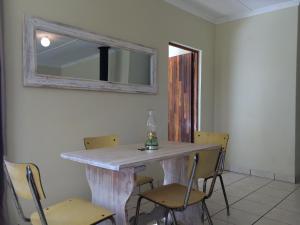 a table with chairs and a mirror on the wall at Moya Cottage in Underberg