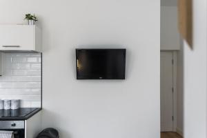 een flatscreen-tv aan een muur in een keuken bij 203, THE KOVÉ, West Hill Road in Bournemouth