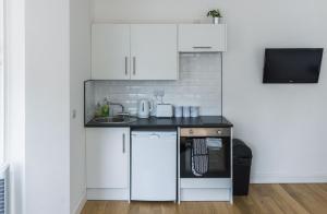 a kitchen with white cabinets and a black counter top at 203, THE KOVÉ, West Hill Road in Bournemouth