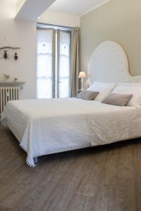 ein großes weißes Bett in einem Schlafzimmer mit Holzboden in der Unterkunft BeB San Lorenzo in Bergamo