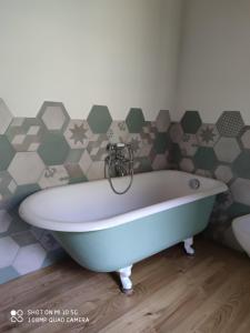 y baño con bañera y pared hexagonal. en La Pezzuola 53, en Sopralacroce