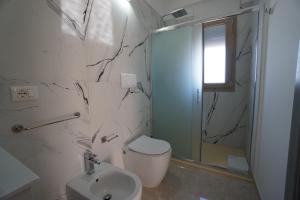 bagno bianco con servizi igienici e doccia di b&b Villa Grazia a Leverano