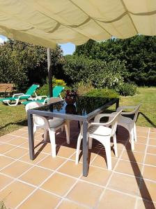 - une table et des chaises sous un parasol sur la terrasse dans l'établissement Moli 1, à Torroella de Montgrí