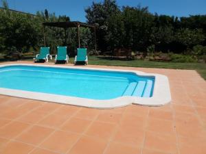 a swimming pool with two chairs and a gazebo at Moli 1 in Torroella de Montgrí