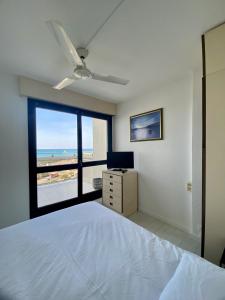 1 dormitorio con cama y vistas a la playa en Le Mousse, P2 cosy avec une magnifique vue mer, parking, en La Grande-Motte