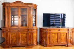 萨拉热窝Apartment Baščaršija Old City view的电视机旁边是一个大木柜。