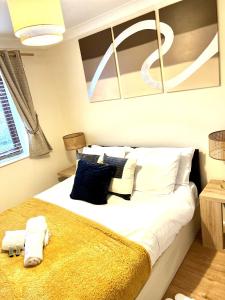 a bedroom with a large bed with blue and white pillows at Campbell Park apartment with a balcony and free parking in Milton Keynes