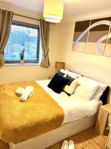a bedroom with a large bed with two towels on it at Campbell Park apartment with a balcony and free parking in Milton Keynes
