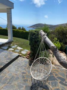 a tree limb tied to a basket on a patio at Greek Sea Villas Kaki Thalassa 400 meters to the beach in Keratea