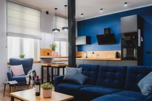 sala de estar con sofá azul y cocina en Modern Apartments Toruń 4, en Toruń