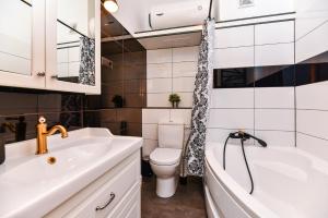 uma casa de banho com um lavatório, um WC e uma banheira em VILLA KURLAND em Ventspils