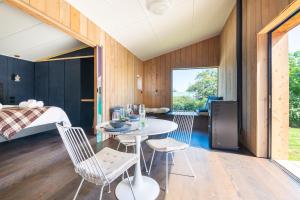 a room with a table and chairs and a bed at The Urban Tramping Hut in Rotorua