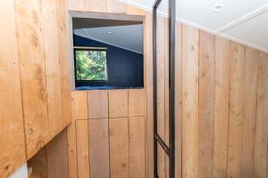 a bathroom with wooden walls and a window at The Urban Tramping Hut in Rotorua