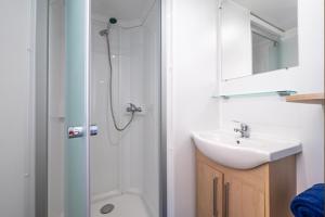 La salle de bains est pourvue d'une douche et d'un lavabo. dans l'établissement Camping La Masia, à Blanes