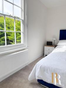 a white bedroom with a bed and a window at Fisherman's Cottage - Harwich Breaks - BRAND NEW - long stays available great prices - get in touch for all bookings - cottage in harwich - beach stay in Harwich