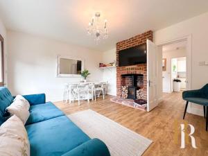 a living room with a blue couch and a fireplace at Fisherman's Cottage - Harwich Breaks - BRAND NEW - long stays available great prices - get in touch for all bookings - cottage in harwich - beach stay in Harwich