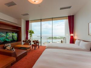 a hotel room with two beds and a flat screen tv at Rakuten STAY Atami in Atami