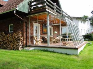 a screened in porch of a brick house with chairs at Pommernhof in Ustronie Morskie