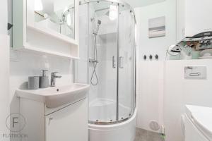 a white bathroom with a shower and a sink at Flatbook Apartamenty - Mikoszewo Wczasowa I in Mikoszewo