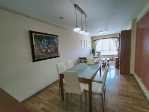 a dining room with a table and white chairs at Apartamento en Sada in Santa María