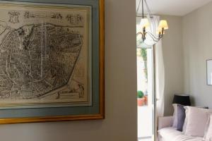 a painting of a map hanging on a wall next to a couch at Les Cachettes in Avignon